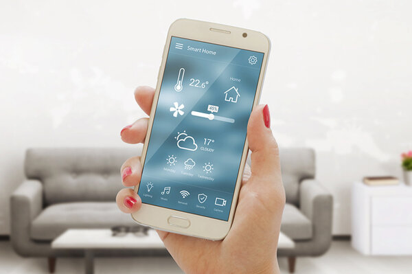 Smartphone in der Hand einer Frau zeigt eine App zur Steuerung von Smart Home-Funktionen für Klimaanlagen