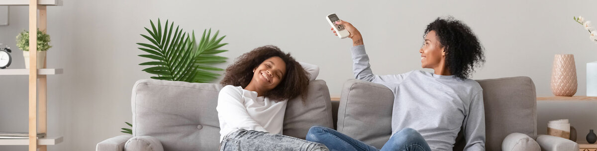 Zwei Frauen sitzen auf dem Sofa und freuen sich über den klimatisierten Raum